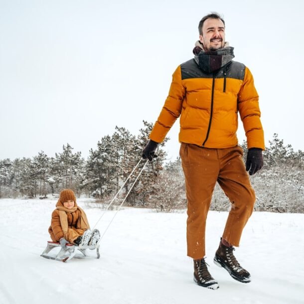 father-pulling-little-son-sledge-winter-min